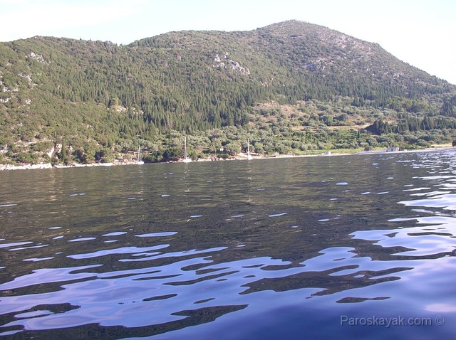 Paddling the glass calm water in the bay of Poli